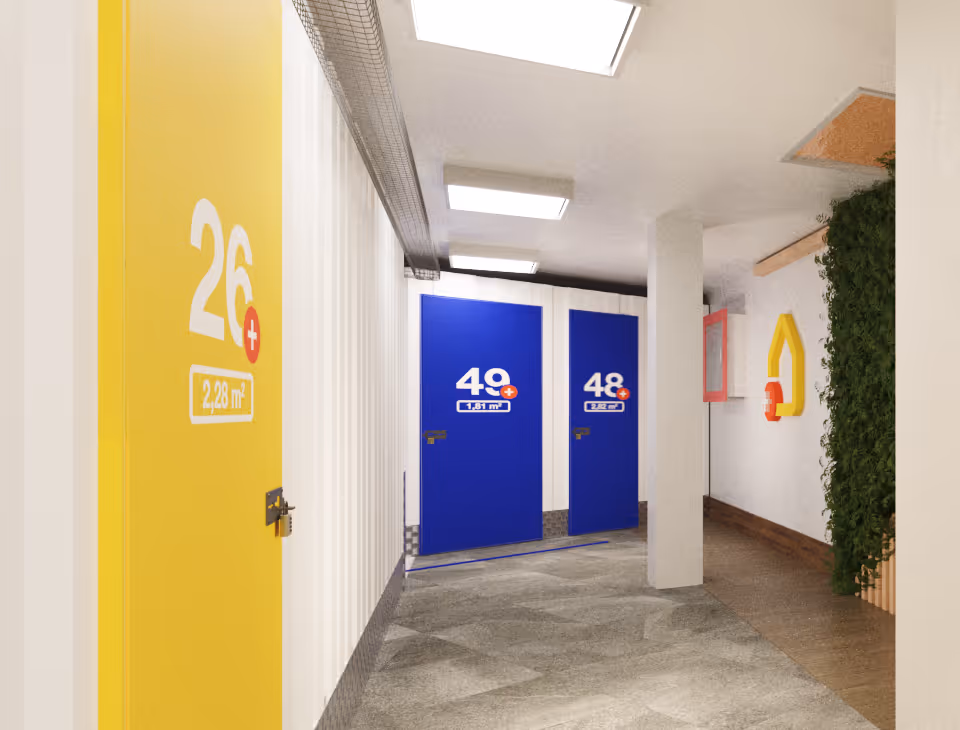 Pasillo de trasteros AticPlus con puertas amarillas y azules
